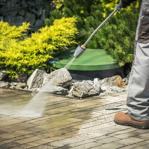 person pressure washing a walkway